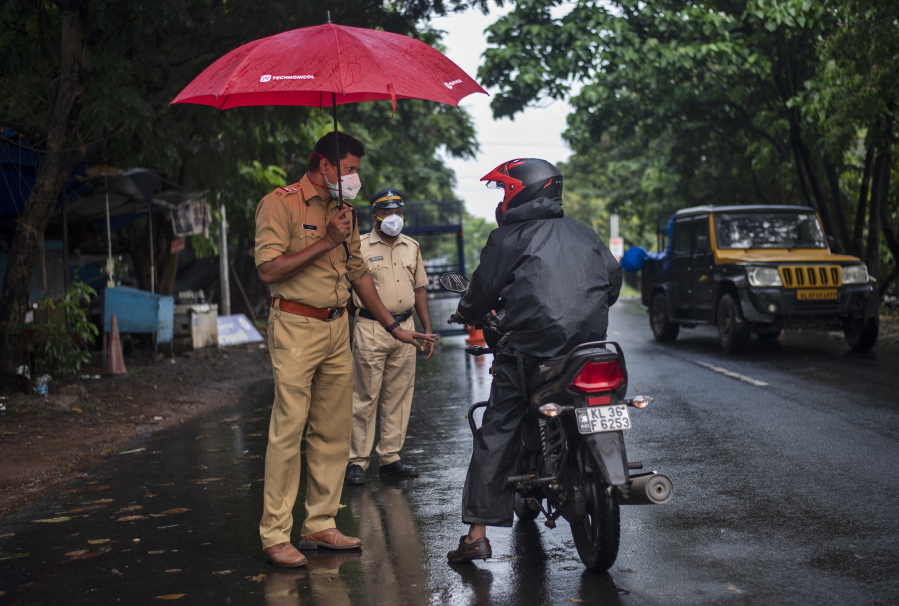 A police officer holds an umbrella to protect himself from the rain as he enforces a lockdown to curb the spread of the coronavirus in Kochi, Kerala state, India, Sunday, May 16, 2021. A severe cyclone is roaring in the Arabian Sea off southwestern India with winds of up to 140 kilometers per hour (87 miles per hour), already causing heavy rains and flooding that have killed at least four people, officials said Sunday.