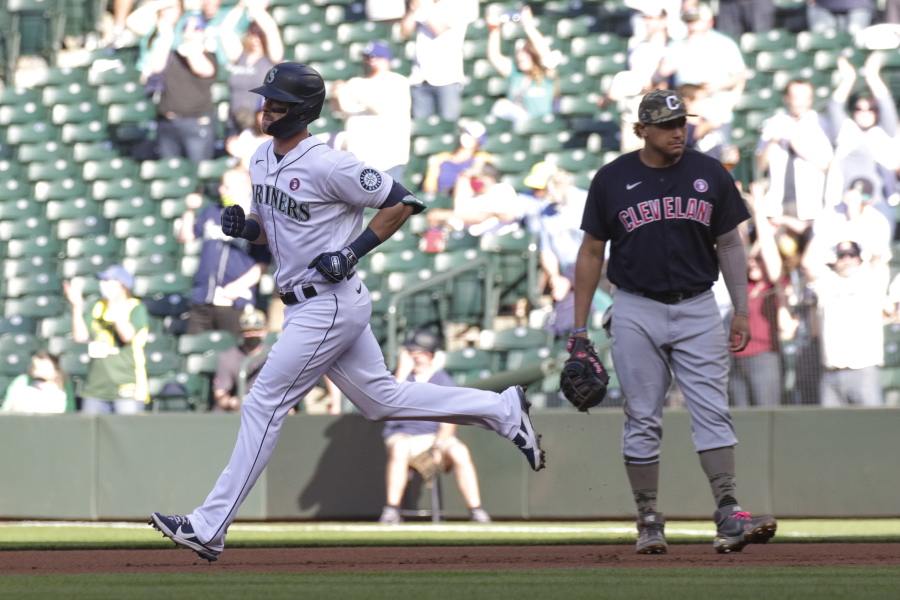 Seattle Mariners' Mitch Haniger runs past Cleveland Indians first baseman Josh Naylor following a solo home run during the first inning of a baseball game Saturday, May 15, 2021, in Seattle.