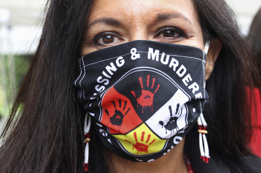 FILE - In this Wednesday, Aug. 26, 2020, file photo, Jeannie Hovland, the deputy assistant secretary for Native American Affairs for the U.S. Department of Health and Human Services, poses with a Missing and Murdered Indigenous Women mask, in Anchorage, Alaska, while attending the opening of a Lady Justice Task Force cold case office in Anchorage, which will investigate missing and murdered Indigenous women. From the nation's capitol to Indigenous communities across the American Southwest, top government officials, family members and advocates are gathering Wednesday, May 5, 2021, as part of a call to action to address the ongoing problem of violence against Indigenous women and children.