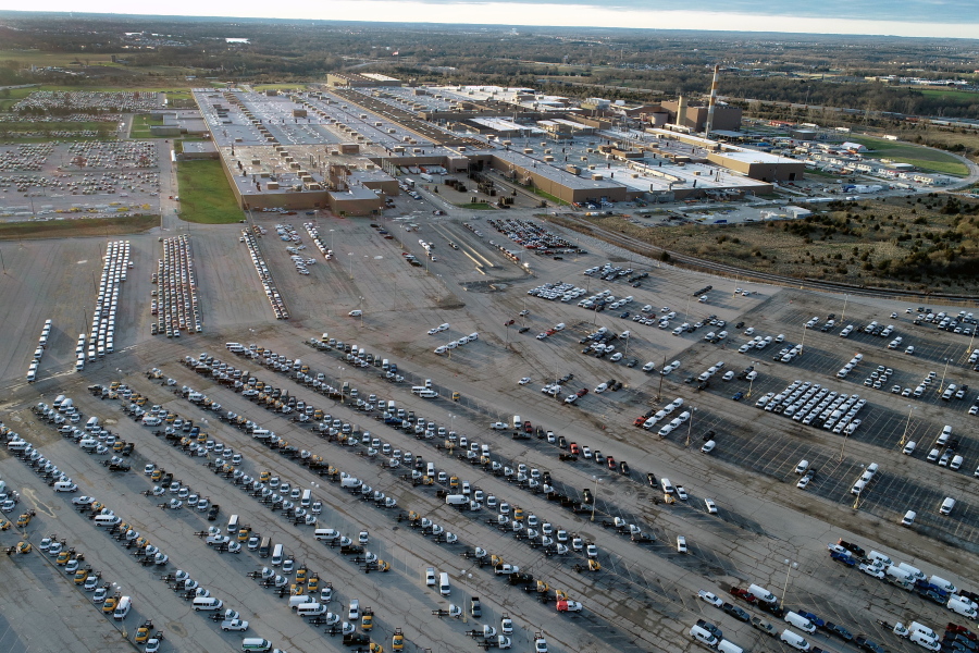 In this aerial photo, a General Motors assembly plant is seen at top right while mid-sized pickup trucks and full-size vans currently produced at the plant are seen in a parking lot outside Wednesday, March 24, 2021, in Wentzville, Mo.  U.S. industrial production increased for a second straight month as more factories came online after being shutdown by winter ice storms. Industrial production - which includes output at factories, mines and utilities - rose 0.7% in April, down from a sharp gain of 2.4% drop in March, the Federal Reserve reported Friday, May 14.