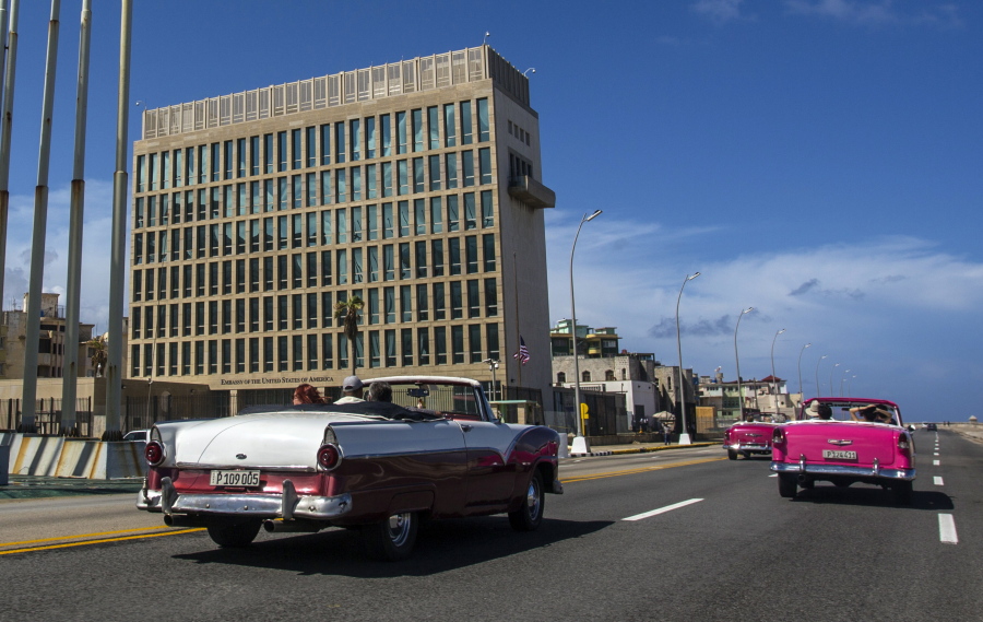 FILE - In this Oct. 3, 2017, file photo, tourists ride classic convertible cars on the Malecon beside the United States Embassy in Havana, Cuba. The Biden administration faces increasing pressure to respond to a sharply growing number of reported injuries suffered by diplomats, intelligence officers and military personnel that some suspect are caused by devices that emit waves of energy that disrupt brain function. The problem has been labeled the "Havana Syndrome," because the first cases affected personnel in 2016 at the U.S. Embassy in Cuba.