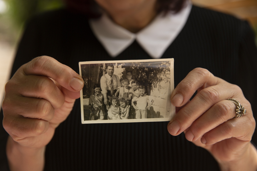 Samira Dajani holds a photo of her family in 1956 after they moved into their home in the Sheikh Jarrah neighborhood of east Jerusalem, Sunday, May 9, 2021. The Dajanis are one of several Palestinian families facing imminent eviction in the Sheikh Jarrah neighborhood of east Jerusalem. The families' plight has ignited weeks of demonstrations and clashes in recent days between protesters and Israeli police.