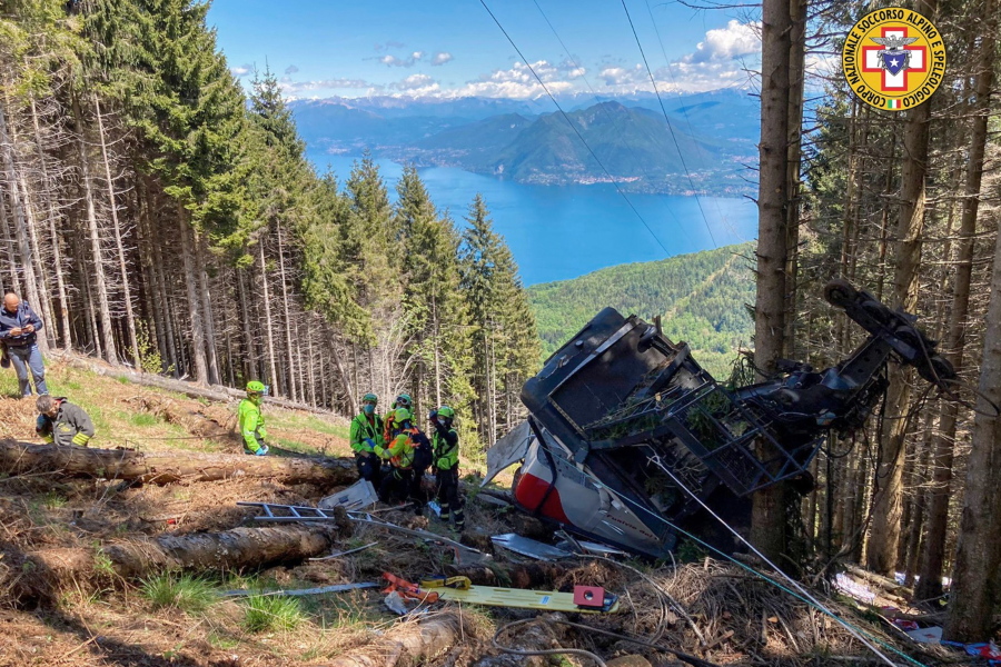 Rescuers work by the wreckage of a cable car after it collapsed near the summit of the Stresa-Mottarone line in the Piedmont region, northern Italy, Sunday, May 23, 2022. A mountaintop cable car plunged to the ground in northern Italy on Sunday, killing at least five people and sending at least three more to the hospital, authorities said.