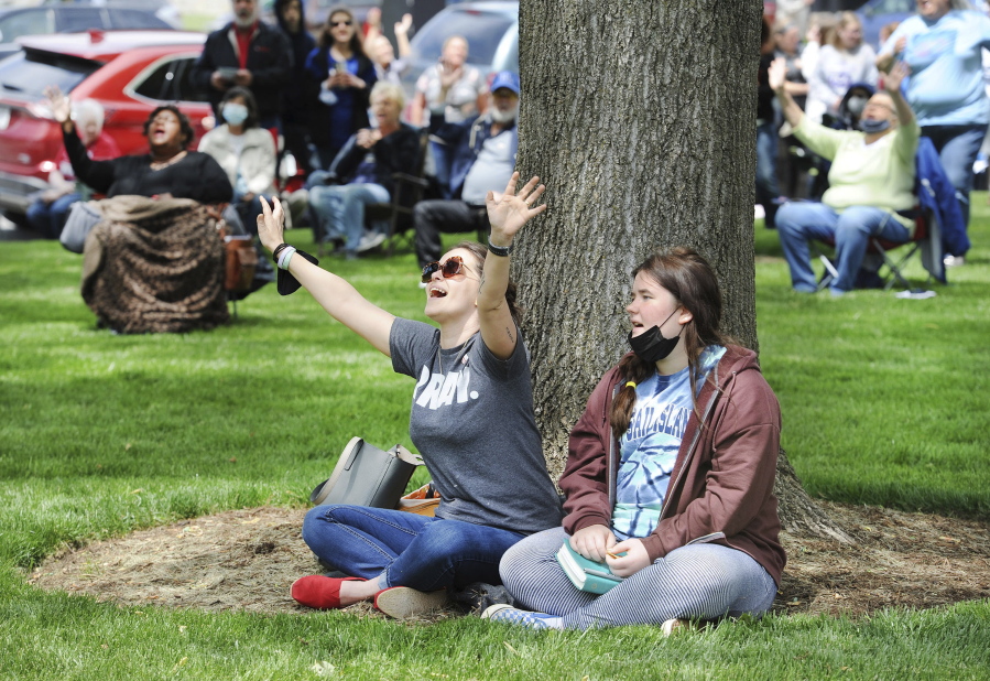 Rae Woodward, left, and Carrie Woodward sing along during a prayer worship service Thursday on the 70th National Day of Prayer on the lawn of the Daviess County Courthouse in Owensboro, Ky.