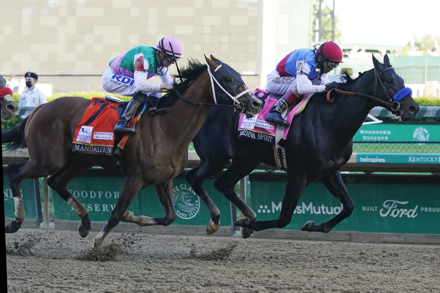John Velazquez, right, rides Medina Spirit ahead of Florent Geroux aboard Mandaloun to win the 147th running of the Kentucky Derby at Churchill Downs, Saturday, May 1, 2021, in Louisville, Ky.