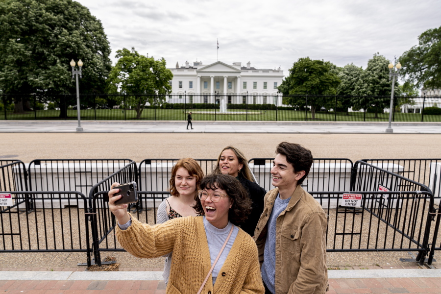From left, Eliana Lord, Carly Mihovich, Stephanie Justice, and Nick Hansen, visiting from Columbia, S.C., take a photo at Lafayette Park, across the street from the White House, after it reopens in a limited capacity in Washington, Monday, May 10, 2021. Fencing remains in place around the park which will allow the Secret Service to temporarily close the park as they deem necessary.