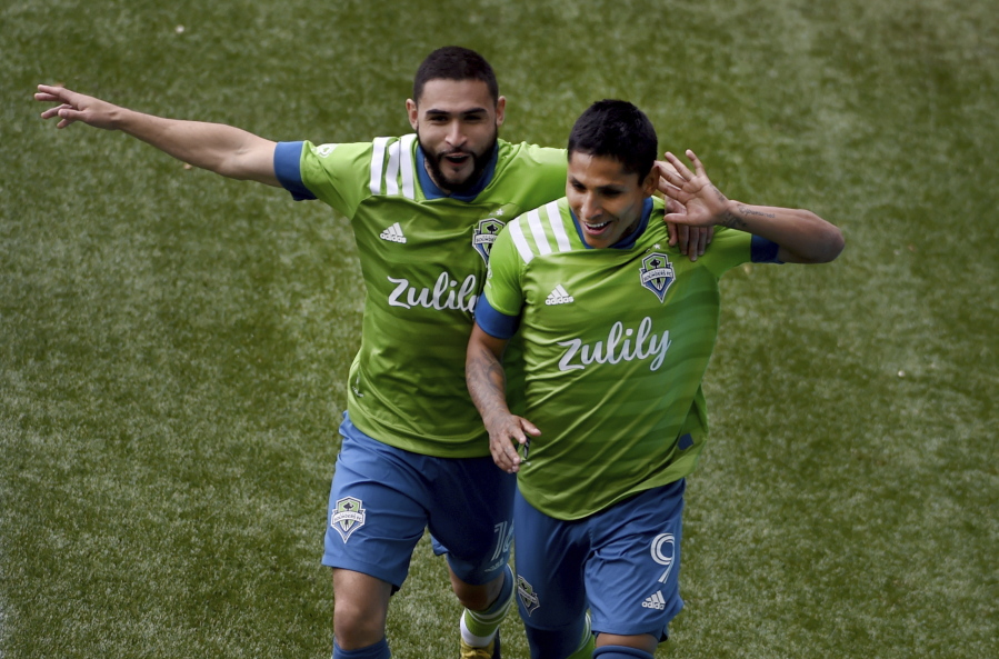 Seattle Sounders forward Raul Ruidiaz, right, celebrates with midfielder Alex Roldan, left, after scoring during second half of an MLS soccer match against the Portland Timbers in Portland, Ore., Sunday, May 9, 2021.