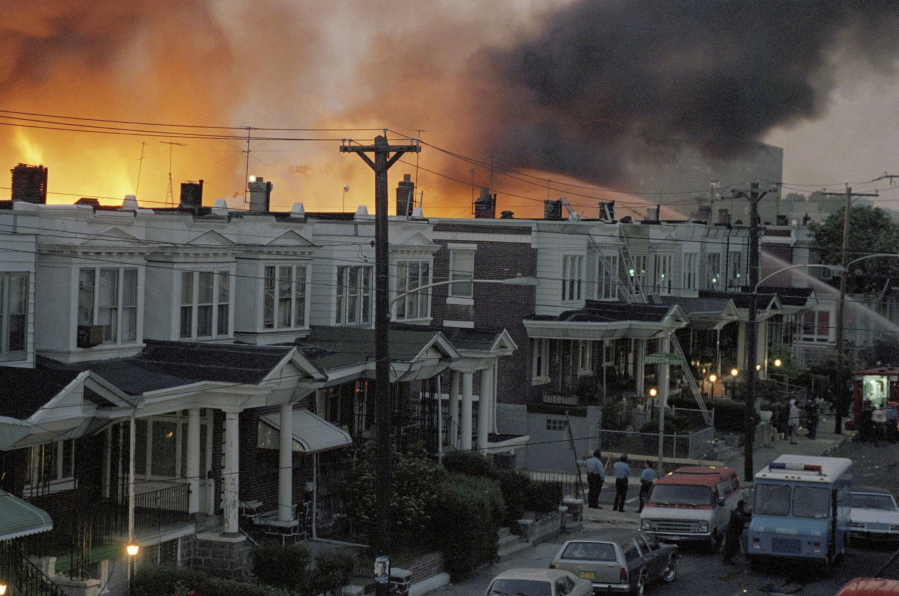 FILE - In this May, 1985 file photo, scores of row houses burn in a fire in the west Philadelphia neighborhood. Police dropped a bomb on the militant group MOVE's home on May 13, 1985 in an attempt to arrest members, leading to the burning of scores of homes in the neighborhood. A day after Philadelphia's health commissioner was forced to resign over the cremation of partial remains thought to belong to victims of a 1985 bombing of the headquarters of a Black organization, the city now says those victims' remains were never destroyed. City officials told the victims' family Friday, May 14, 2021 that a subordinate had disobeyed Health Commissioner Thomas Farley's 2017 order to dispose of the remains.