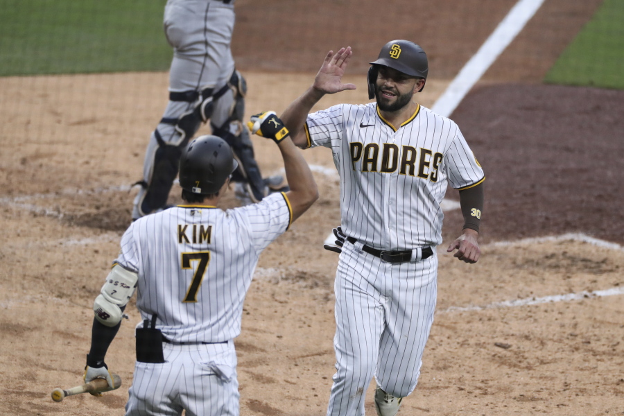 San Diego Padres' Eric Hosmer, right, is congratulated by Ha-Seong Kim (7) after scoring against the Seattle Mariners during the fifth inning of a baseball game Saturday, May 22, 2021, in San Diego.