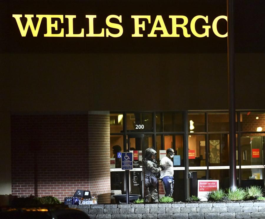 Police lead Ray Reco McNeary away from the Wells Fargo branch following a standoff of more than eight hours Thursday May 6, 2021, in St. Cloud, Minn.   McNeary was disgruntled about a prior transaction, according to St. Cloud, police Chief Blair Anderson.  (Dave Schwarz/St.