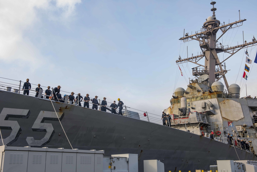 In this photo provided by the U.S. Navy, sailors aboard the guided missile destroyer USS Stout handle mooring lines during the ship's return to home port at Naval Station Norfolk, in Norfolk, Va., in this Oct. 12, 2020, photo. The USS Stout showed rust as it returned from the 210-day deployment. The rust was quickly removed and the ship repainted. But the rusty ship and its weary crew underscored the costly toll of deferred maintenance on ships and long deployments on sailors. (Spc. Jason Pastrick/U.S.