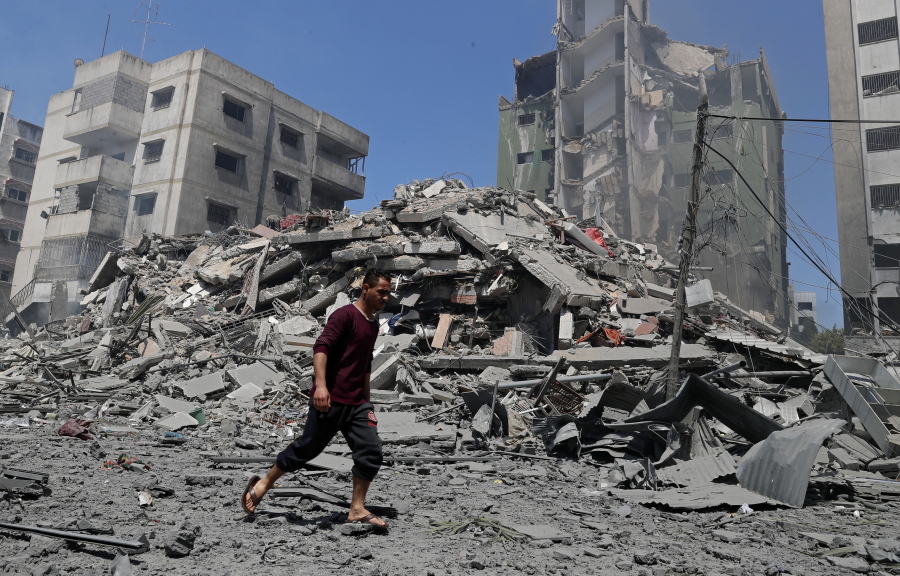A man walks past the the rubble of the Yazegi residential building that was destroyed by an Israeli airstrike, in Gaza City, Sunday, May 16, 2021. The 57-member Organization of Islamic Cooperation held an emergency virtual meeting Sunday over the situation in Gaza calling for an end to Israel's military attacks on the Gaza Strip.