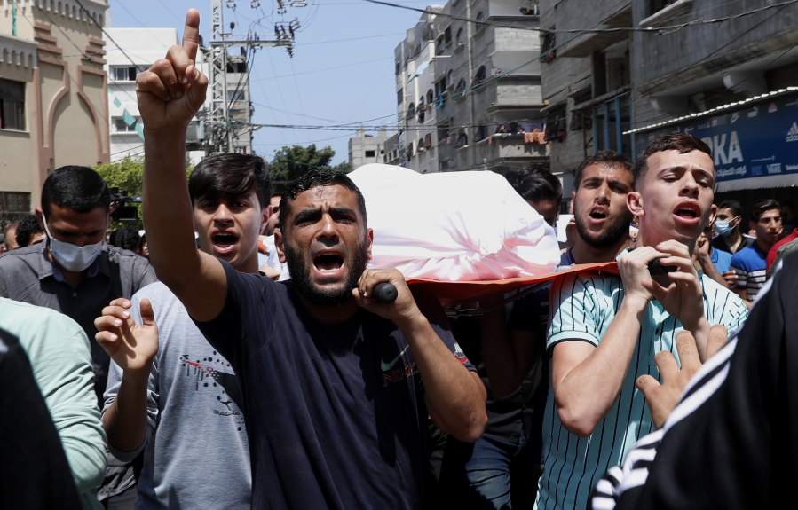 Mourners chant Islamic slogans while they carry the body of Amira Soboh, and her 19-year-old disabled son Abdelrahman, who were killed in Israeli airstrikes at their apartment building,  during their funeral at the Shati refugee camp, in Gaza City, Tuesday, May 11, 2021.