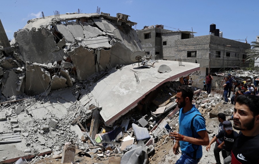 People inspect the rubble of a destroyed residential building which was hit by Israeli airstrikes, in Gaza City, Wednesday, May 12, 2021.