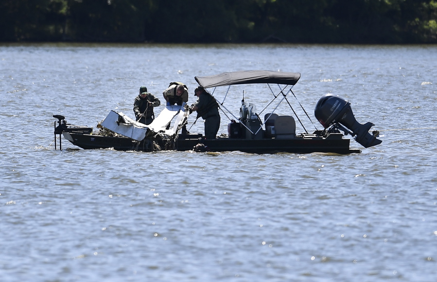 Emergency personnel remove debris from a plane crash in Percy Priest Lake Sunday, May 30, 2021, near Smyrna, Tenn. A small jet carrying seven people crashed Saturday, and authorities indicated that no one on board survived.