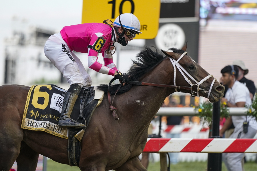 Flavien Prat atop Rombauer reacts as he crosses the finish line to win the Preakness Stakes horse race at Pimlico Race Course, Saturday, May 15, 2021, in Baltimore.