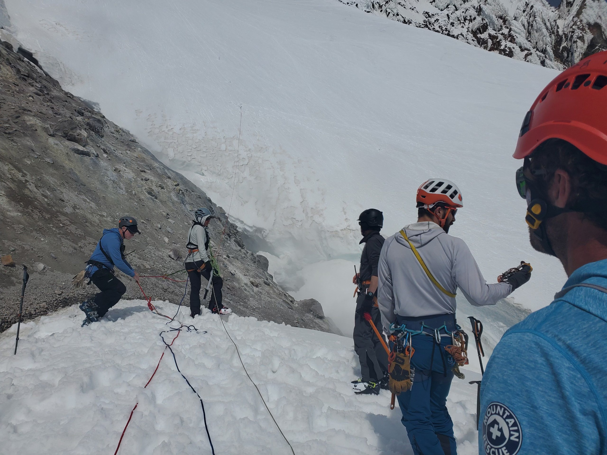 Rescue crews on Mount Hood begin descending a steep slope above where a climber fell to his death on Sunday morning.