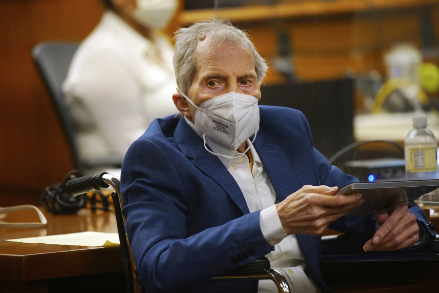 Robert Durst holds a device to read the real time spoken script as he appears in the courtroom of Judge Mark E. Windham as attorney's begin opening statements in the trial of the real estate scion charged with murder of longtime friend Susan Berman, at Los Angeles County Superior Court, Tuesday, May 18, 2021, in Inglewood, Calif. Durst's murder trial was delayed more than a year due to the Covid-19 pandemic.