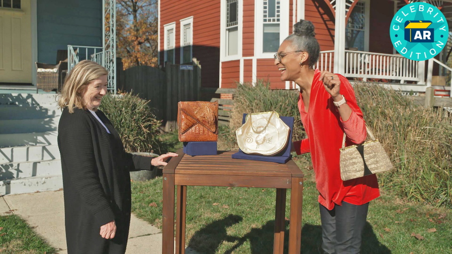 This image released by WGBH-TV shows Katy Kane, left, as she appraises celebrity chef Carla Hall's vintage purse collection in an episode of "Antiques Roadshow Celebrity Edition," airing May 10 on PBS.