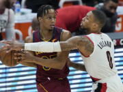 Portland Trail Blazers' Damian Lillard (0) defends against Cleveland Cavaliers' Isaac Okoro during the second half of an NBA basketball game Wednesday, May 5, 2021, in Cleveland.