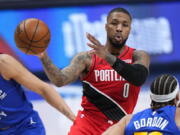 Portland Trail Blazers guard Damian Lillard (0) passes the ball against the Denver Nuggets during the second half of Game 1 of a first-round NBA basketball playoff series Saturday, May 22, 2021, in Denver.