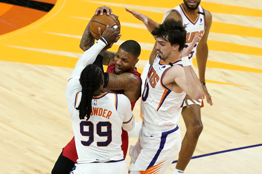 Portland Trail Blazers guard Damian Lillard is pressured by Phoenix Suns forward Jae Crowder (99) and forward Dario Saric, right, during the second half of an NBA basketball game, Thursday, May 13, 2021, in Phoenix.