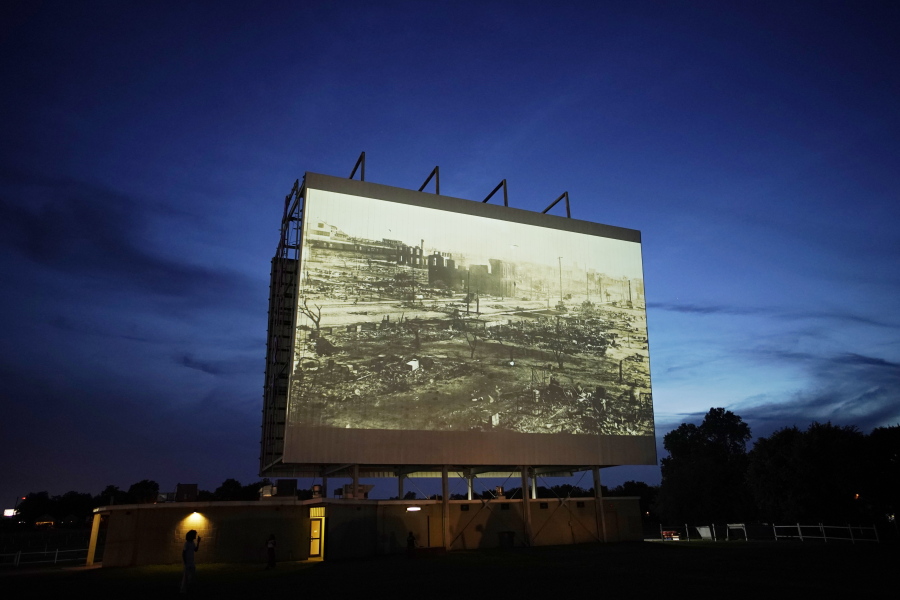 An image of devastation from the Tulsa Race Massacre is shown on a drive-in screen from a documentary called "Rebuilding Black Wall Street," during a screening of documentaries during centennial commemorations of the Tulsa Race Massacre, Wednesday, May 26, 2021, in Tulsa, Okla.