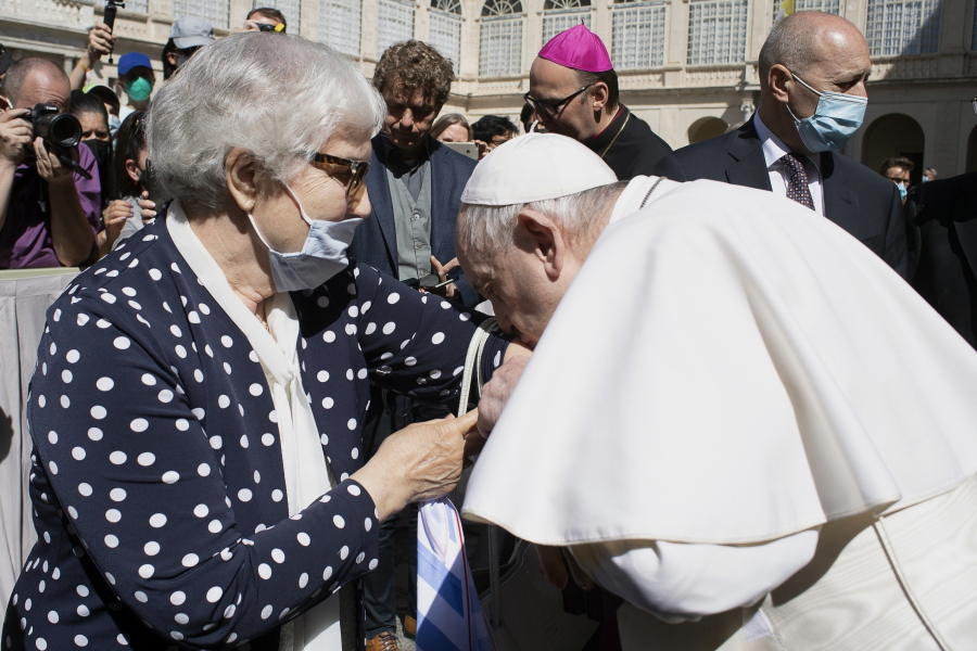 Pope Francis leans and kiss a tattoo on the arm of Holocaust survivor Lidia Maksymowicz, a Polish citizen who was deported to Auschwitz from her native Belarus, during his weekly general audience at the Vatican, Wednesday, May 26, 2021. Pope Francis has kissed the tattoo of an Auschwitz survivor during a general audience on Wednesday. Lidia Maksymowicz, a Polish citizen who was deported to Auschwitz from her native Belarus, showed the pope the number tattooed on her arm by the Nazis, and Francis leaned over and kissed it Wednesday. Maksymowicz told Vatican News that she did not exchange words with the pope.