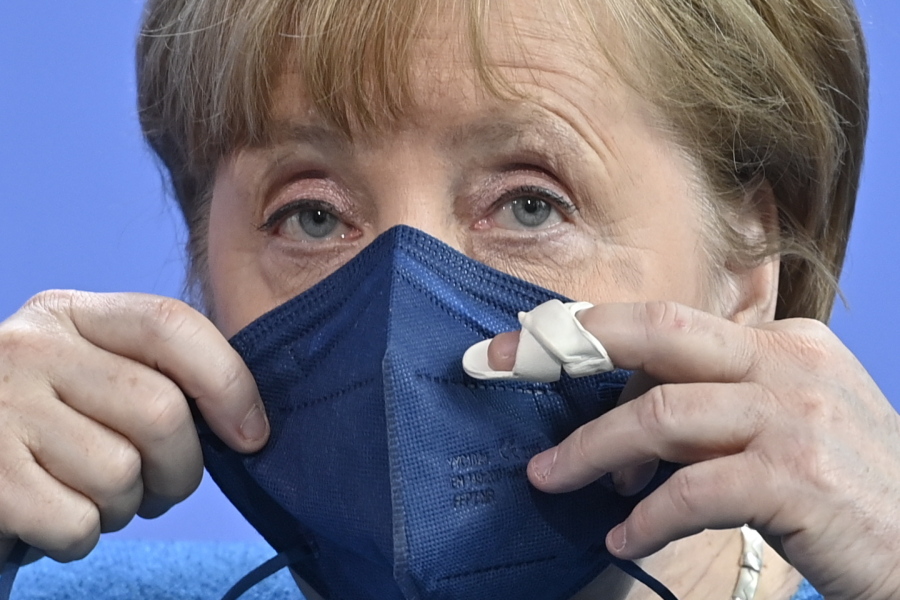 German Chancellor Angela Merkel puts her face mask on after a press conference after the informal EU summit and the EU-China summit in Berlin, Germany, Saturday, May 8, 2021. Merkel reiterated her stance that the shortage of vaccines worldwide would not be solved by a waiver of patents, as suggested by U.S. President Biden.
