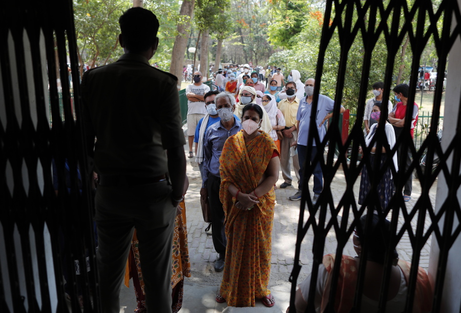Indians line up to receive the vaccine for COVID-19 at a medical college in Prayagraj, India, Saturday, May 8, 2021. Two southern states in India became the latest to declare lockdowns, as coronavirus cases surge at breakneck speed across the country and pressure mounts on Prime Minister Narendra Modi's government to implement a nationwide shutdown.