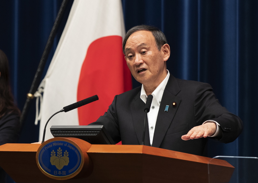 Japanese Prime Minister Yoshihide Suga responds to a reporter's question after he spoke at a news conference in Tokyo on Friday, May 7, 2021. Suga announced an extension of a state of emergency in Tokyo and other areas through May 31.