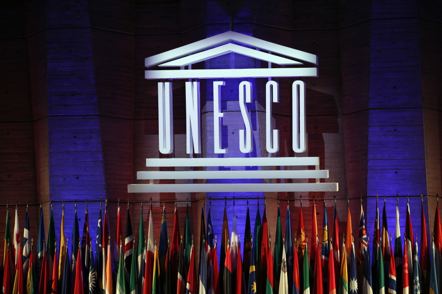 FILE - In this Nov.4, 2017 file photo, the logo of the United Nations Educational, Scientific and Cultural Organisation (UNESCO) is seen during the 39th session of the General Conference at the UNESCO headquarters in Paris. While the U.S. president is calling for suspending patents on COVID-19 vaccines, experts at UNESCO are quietly working on a more ambitious plan: a new global system for sharing scientific knowledge that would outlast the current pandemic.