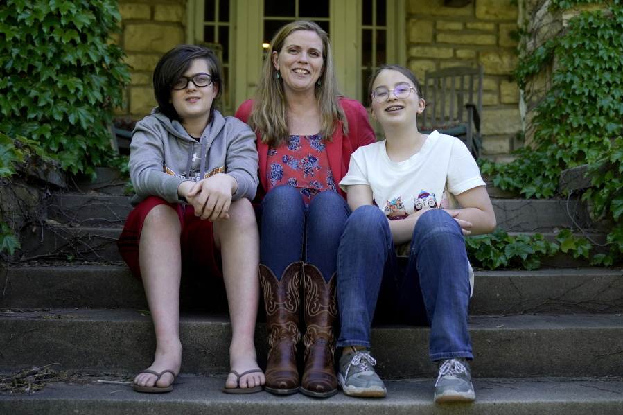 Heather Ousley sits with her older children Elliannah, 15, right, and Samuel, 13, in front of their home in Merriam, Kan, Tuesday, May 4, 2021. Ousley was thrilled when she heard the FDA was expected to authorize Pfizer's COVID-19 vaccine for youngsters ages 12 to 15 and was hoping to get her kids vaccinated as soon as she can.