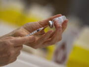 FILE - In this file photo dated Wednesday, April 14, 2021, a pharmacist fills a syringe from a vial of the Moderna COVID-19 vaccine in Antwerp, Belgium.  Moderna and vaccine promoter Gavi have announced Monday May 3, 2021, the pharmaceutical company will provide up to 500 million coronavirus vaccine doses for the U.N.-backed program for needy people in low- and middle-income countries by the end of 2022.