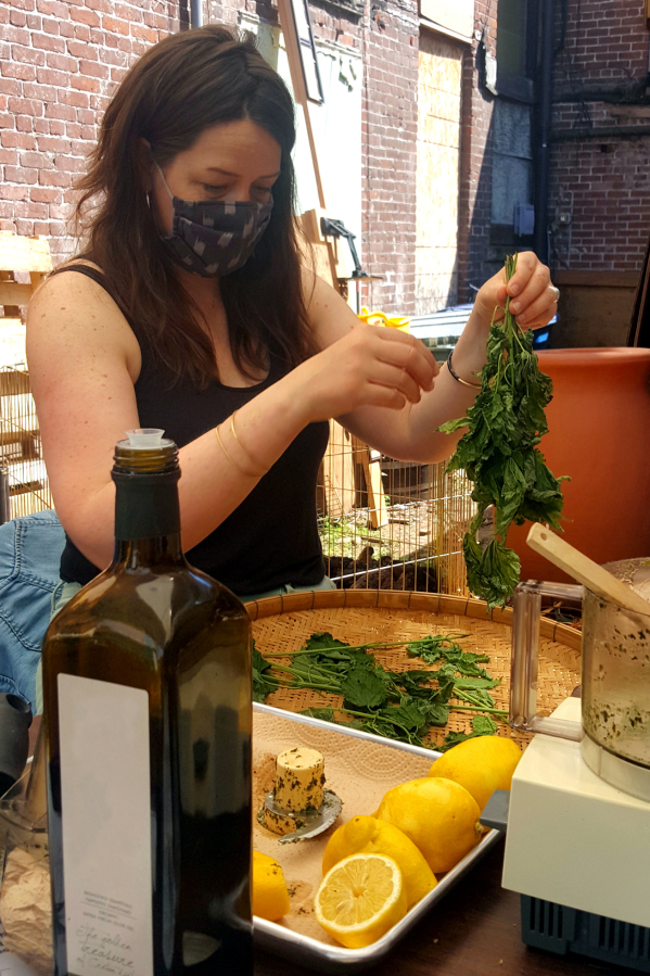 Self-described "folk herbalist" Emily Reudink teaches students how to make nettle pesto at an outdoor workshop at Kindred Homestead Supply.