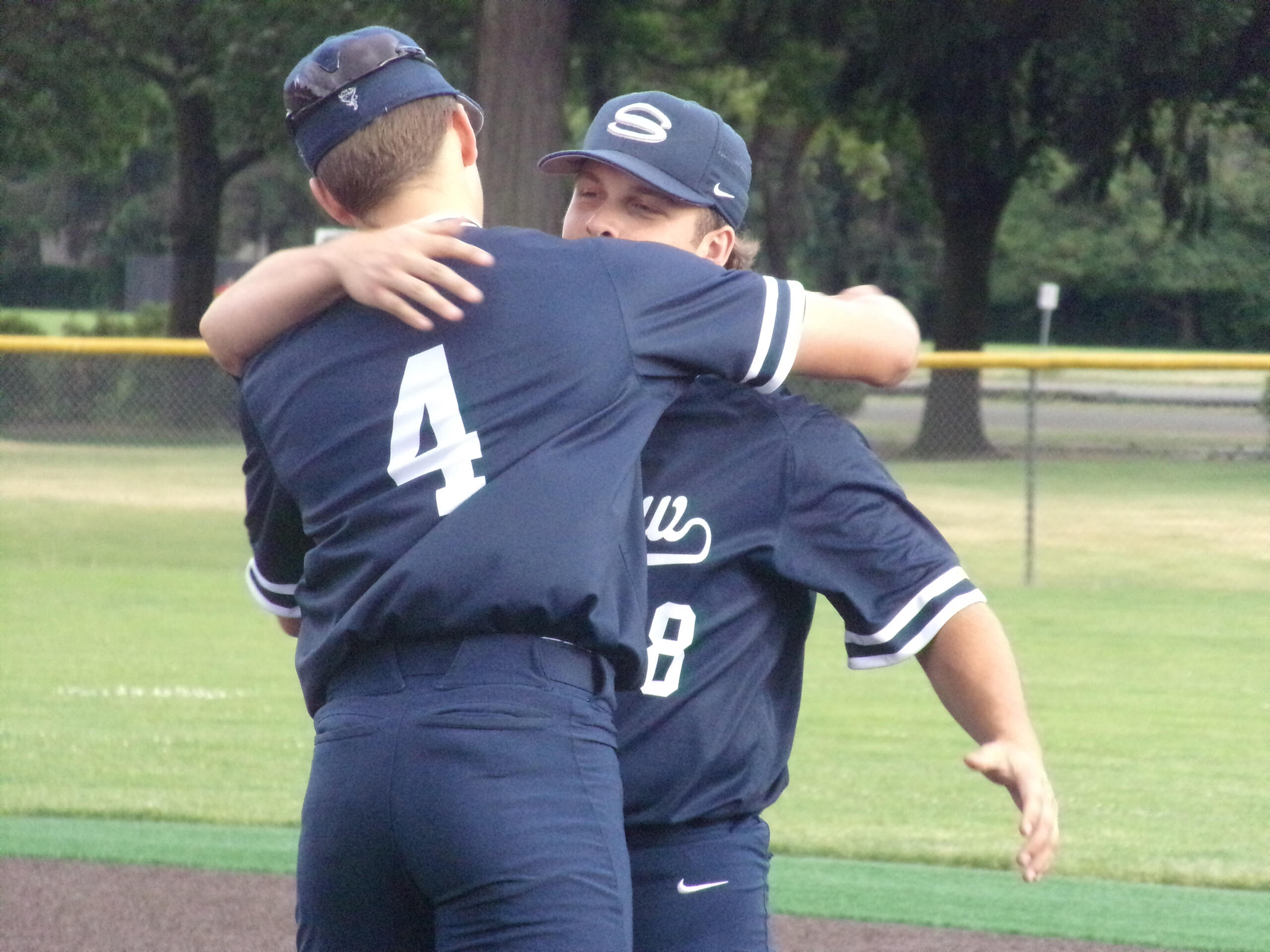 Kyle Olson (4) hugs fellow senior Mikey Miller after Skyview's 8-3 win over Prairie in the 4A/3A Greater St.