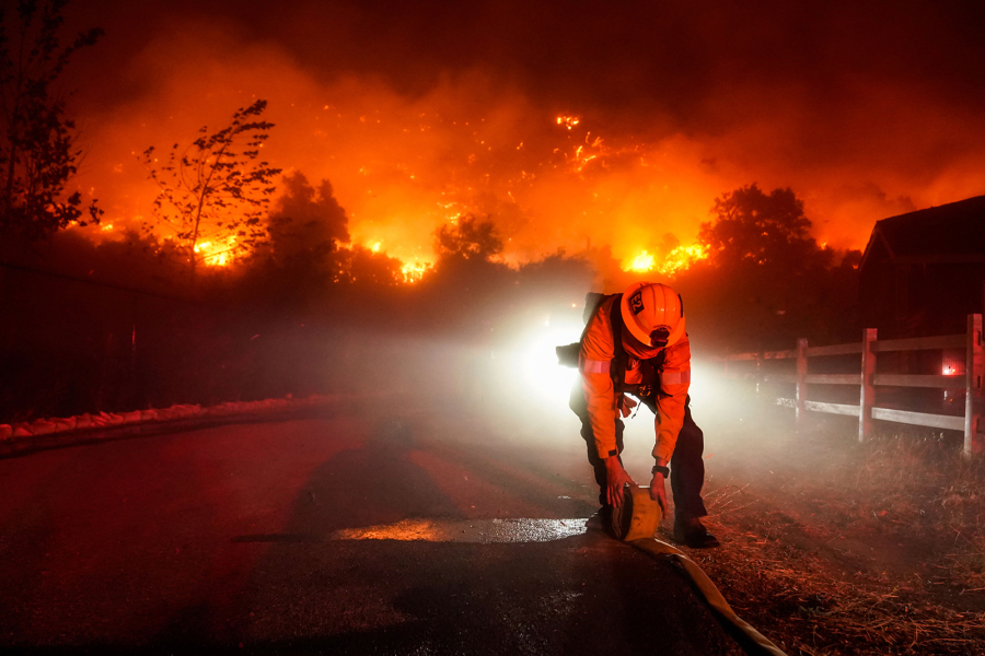 Firefighters battle the Bond fire, started by a structure fire that extended into nearby vegetation, in Silverado, Calif., on Thursday, Dec. 3, 2020. In 2020 alone, wildfires in California caused estimated insured losses of $8 billion.