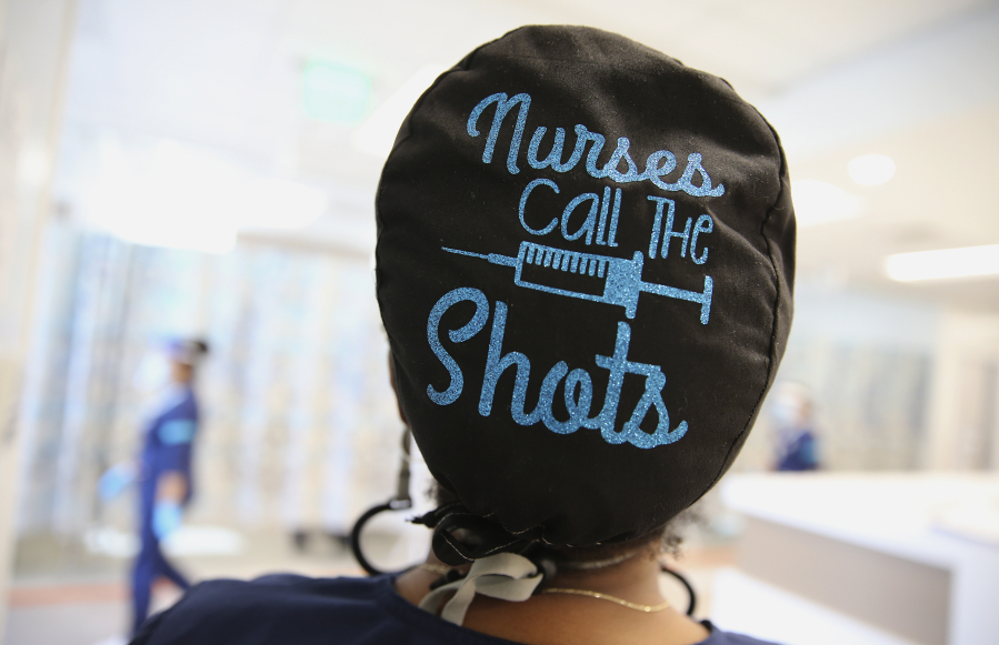 Travel nurse Tiquella Russell of Texas displays her scrub cap shortly after administering a dose of the COVID-19 vaccine at a clinic at Martin Luther King Jr. Community Hospital in South Los Angeles on Feb. 25, 2021. African Americans and Latinos comprise a majority of the South LA community and are dying of COVID-19 at a rate significantly higher than whites. Vaccine equity has also lagged in South Los Angeles relative to some more wealthy areas.