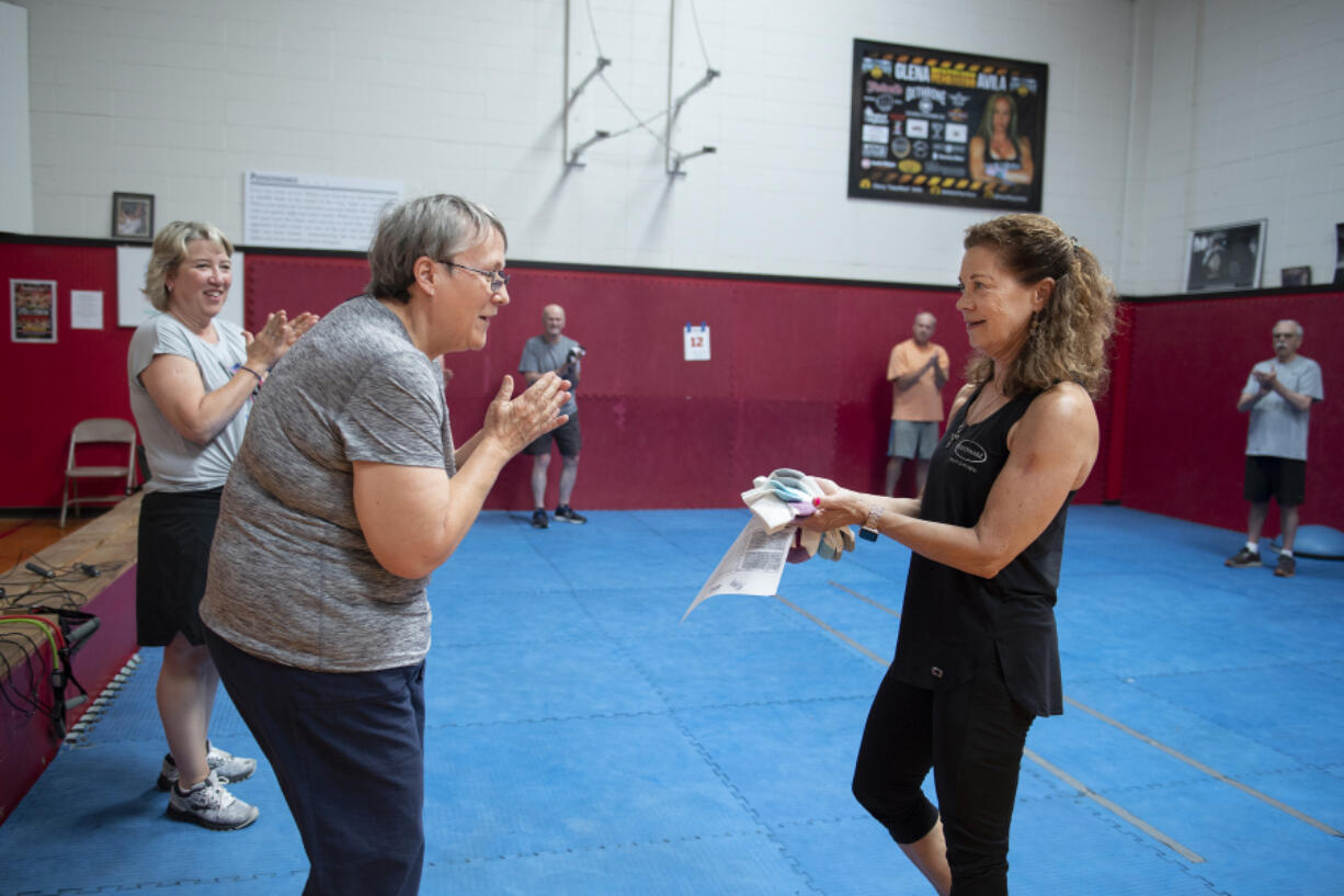 Suzanne Haidri, left, receives a pair of socks from trainer Jan Beyer for having perfect attendance the previous month at Fisticuffs Gym in Vancouver.