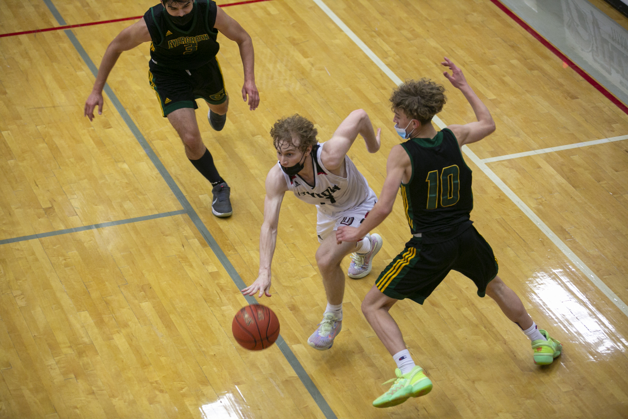 Union's Bryson Metz dribbles down court under pressure from Evergreen players in the 4A/3A GSHL boys basketball playoff game at Union High School on Thursday, June 3, 2021.