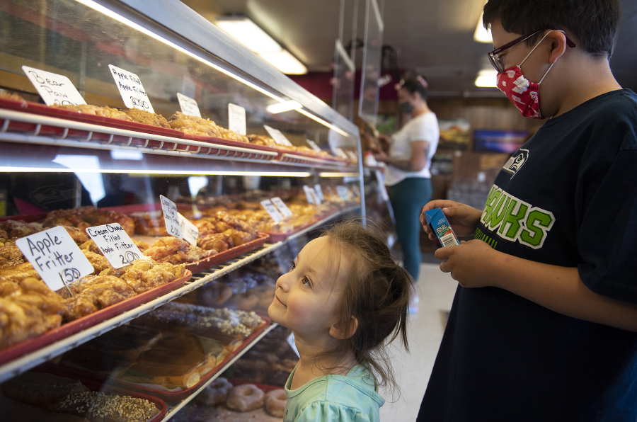 Eileen Baye, 2, left, of Vancouver and her brother, Dylan, 9, look over the selection at the Donut Nook.