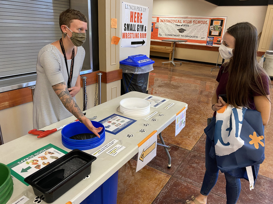WASHOUGAL: Alex Yost and Shannon Brennan chat at a table used to sort recyclables and food waste at Washougal High School.