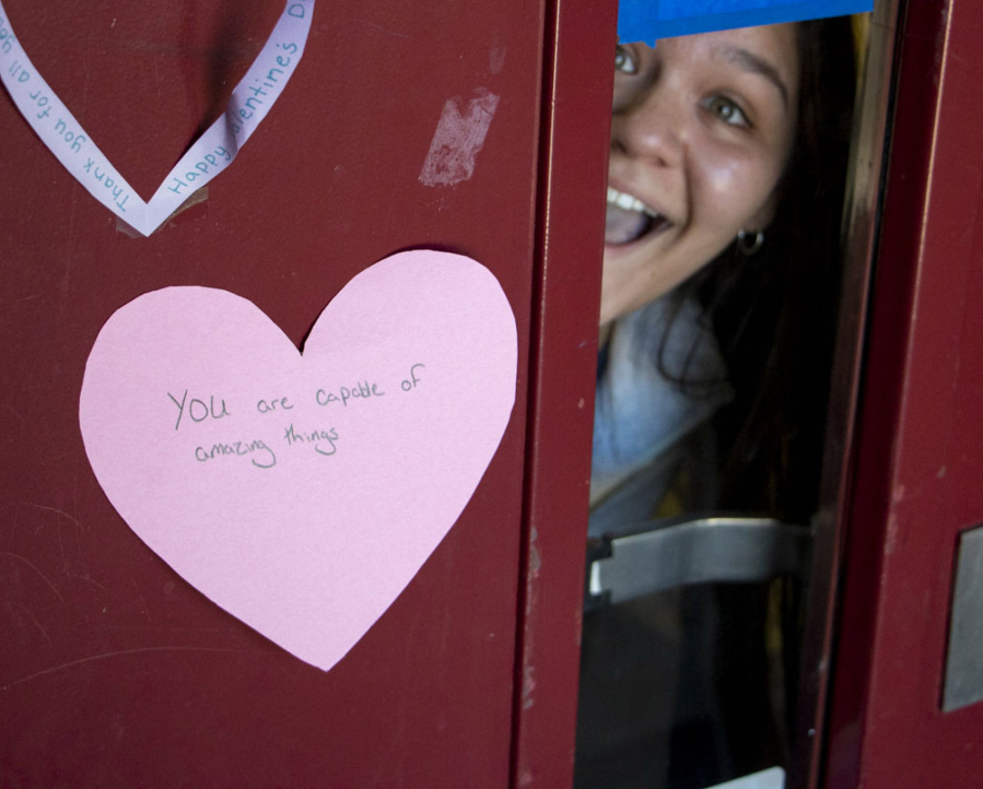 BATTLE GROUND: Prairie High School sophomore Soledad Ahumada peeks out from a door holding a heart with an inspirational message.