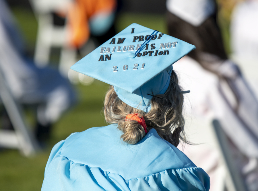 A decorated cap sits on the head of a graduate during the Clark College Commencement ceremony Thursday at Kim Christiansen Field.