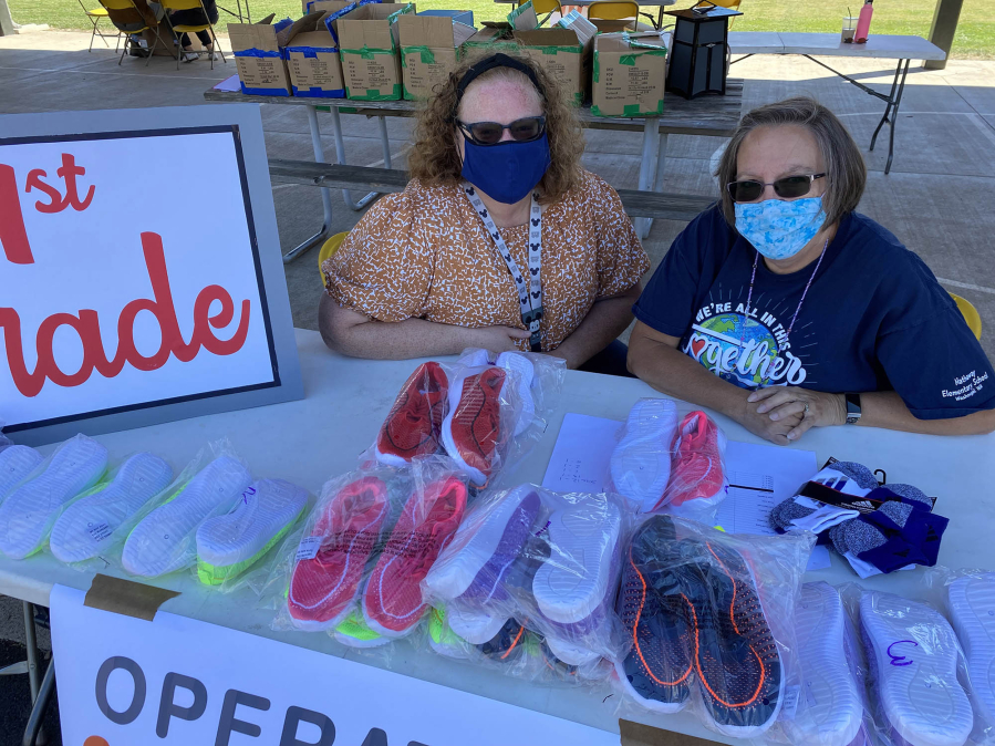 WASHOUGAL: Penny Porche and Nancy Boon, Washougal School District family resource coordinators, helped students pick up their new shoes at the Shoe-a-palooza event.