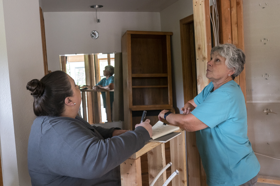 Elizabeth Gomez, owner of Bridge City Contracting, left, talks with Judie Stanton, a former Clark County commissioner, about her bathroom remodel. Gomez has an Aging-in-Place Specialist certification through the National Association of  Home Builders. She's helping Stanton design her home to accommodate needs she may have in the future as she ages. "Typically what happens is people will wait until an event happens like a stroke when they start thinking about modifications to their home," Gomez said.