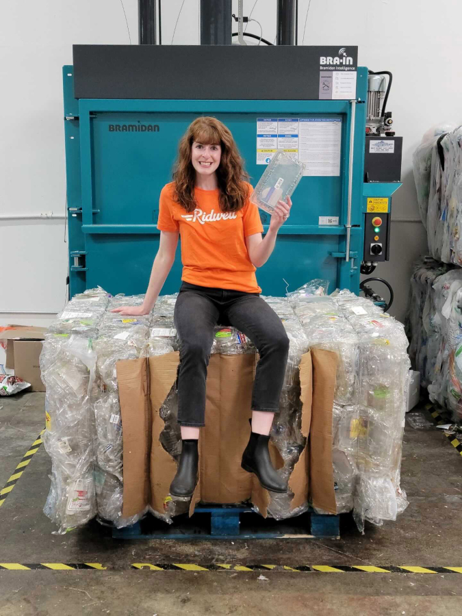 Taylor Loewen, Southwest Washington manager for Ridwell, sits on a bale of clamshells collected for recycling by Green Impact Plastics. Ridwell, which collects hard-to-recycle items, is launching service in Vancouver, Hazel Dell and Salmon Creek.