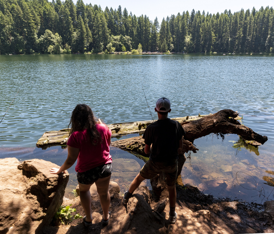 Chloe, 10, left, and Van Hoots, 12, of Salmon Creek, stand on the shores of Battle Ground Lake to fish on Saturday at Battle Ground Lake State Park.