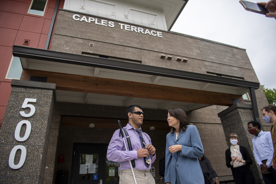 Miguel Viveros Chavez, resident at Caples Terrace, left, chats with Sen. Maria Cantwell after speaking to members of the media about the federal debate over infrastructure at Caples Terrace in Vancouver on Wednesday morning.