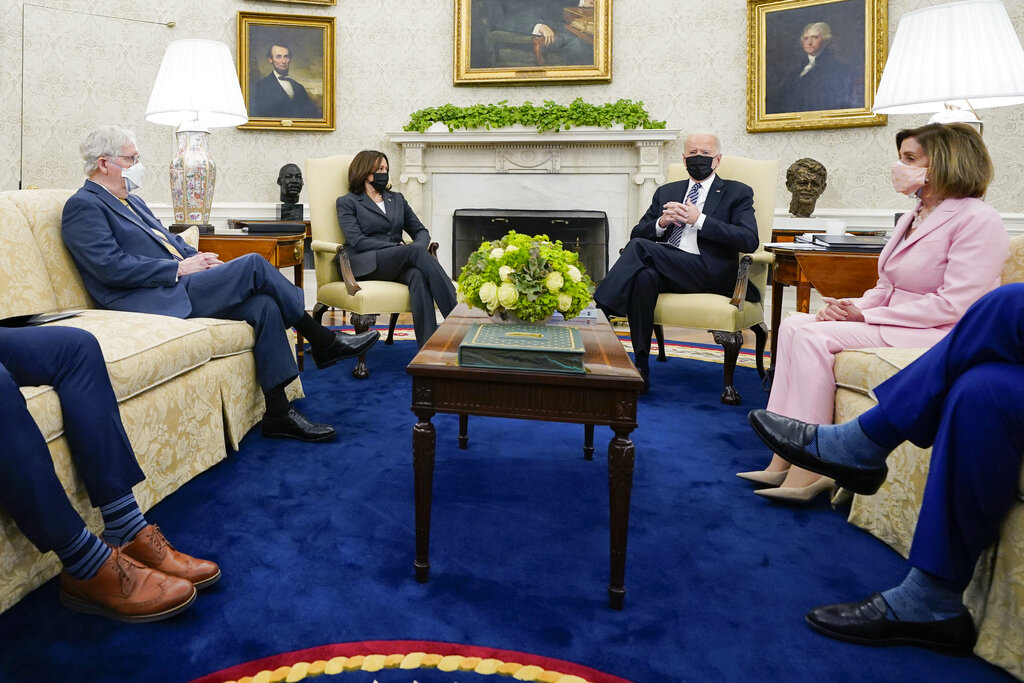 FILE - In this May 12, 2021, file photo President Joe Biden speaks during a meeting with congressional leaders in the Oval Office of the White House in Washington. From left, House Minority Leader Kevin McCarthy of Calif., Senate Minority Leader Mitch McConnell of Ky., Vice President Kamala, Biden, House Speaker Nancy Pelosi of Calif., and Senate Majority Leader Chuck Schumer of N.Y. Congress is hunkered down, grinding through an eight-week stretch as the president’s Democratic allies in the House and Senate try to shape his big infrastructure ideas into bills that could actually be signed into law. Perhaps not since the drafting of Obamacare more than a decade ago has Washington tried a legislative lift as heavy as this.